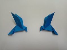 two blue origami birds sitting side by side