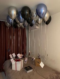 a bed with balloons and presents on it