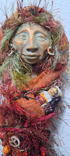 a scarecrow head is adorned with yarn and beads