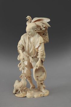 a carved ivory figurine of a man with two chickens and a bird on his shoulder