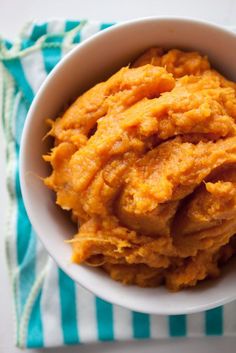 a bowl filled with mashed sweet potatoes on top of a blue and white towel