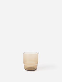 an empty glass sitting on top of a white surface