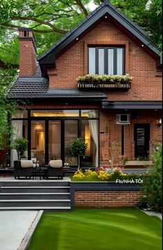 a brick house with lots of windows and landscaping