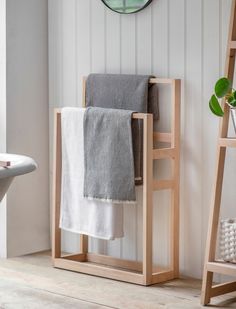 a towel rack with two towels on it next to a mirror and ladder in a bathroom