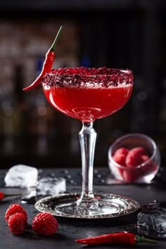 a red cocktail with raspberries on the rim and garnished in sugar