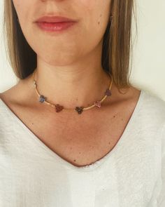 a close up of a woman wearing a white shirt and a necklace with hearts on it