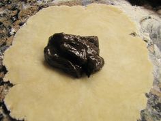 a piece of food sitting on top of a floured pan with some sort of substance in it