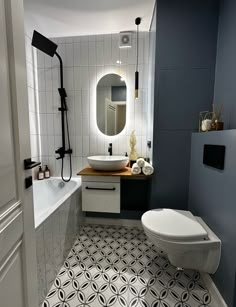 a bathroom with a toilet, sink and bathtub next to a shower head mounted on the wall