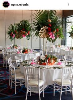 an image of a banquet room setting with flowers and palm trees in the centerpieces