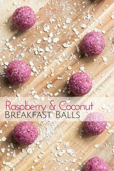 raspberry and coconut breakfast balls on a cutting board with oats scattered around them