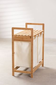 a wooden laundry hamper sitting on top of a floor next to a white wall