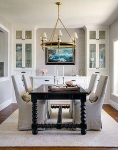 a dining room table with chairs and a chandelier hanging from it's ceiling