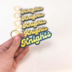 a person is holding up some magnets with the words knights on them and there are other magnets in front of them