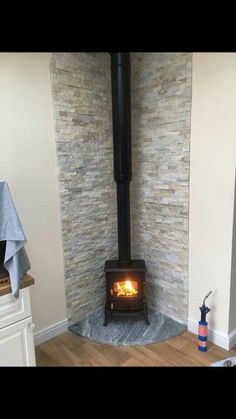 a wood burning stove sitting inside of a kitchen next to a counter top with a towel on it