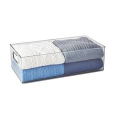 two folded towels in a clear box on top of each other with blue and white blankets