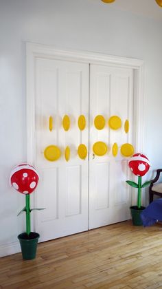 the room is decorated with yellow circles and red mushrooms on the wall, along with green potted plants