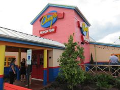 the exterior of a restaurant with people standing outside