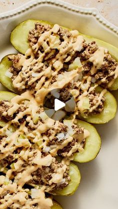 stuffed cucumbers topped with ground beef and sauce on a white plate, ready to be eaten