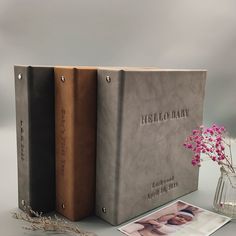 two books sitting next to each other on top of a white table with pink flowers