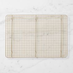 a gridded cutting board on a marble surface