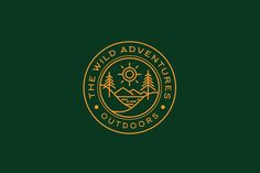 the wild adventurers logo on a dark green background with gold lettering and an image of mountains