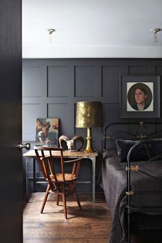 a bedroom with black walls and wooden floors