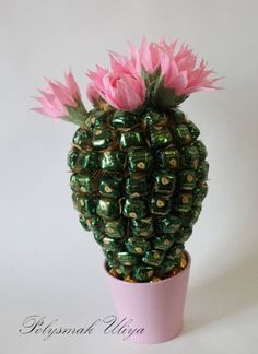 a green and pink potted plant sitting on top of a white table