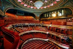 an auditorium filled with lots of red seats