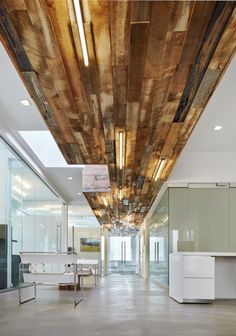 an empty office with wooden ceilings and white furniture