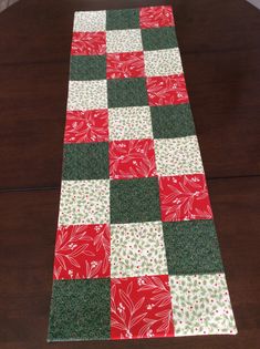 a red and green table runner sitting on top of a wooden table