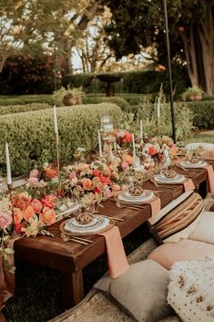 an outdoor dinner table with candles and flowers