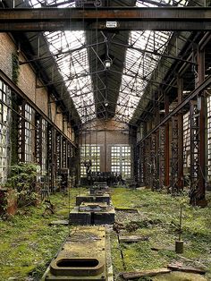 an abandoned building with lots of windows and grass