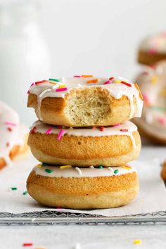 a stack of doughnuts with white frosting and sprinkles on top