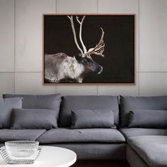 a living room with a couch, coffee table and painting on the wall above it