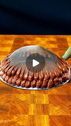 a chocolate cake sitting on top of a wooden table next to a green toothbrush