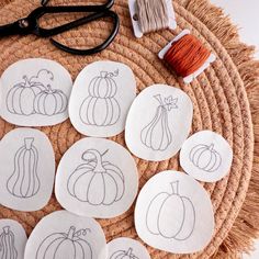 embroidered pumpkins and squash coasters on a woven placemat with scissors, thread and twine