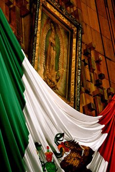 the flag of mexico is draped in front of an ornate painting