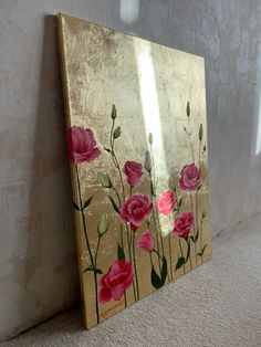 a painting with pink flowers painted on it next to a white wall and carpeted floor