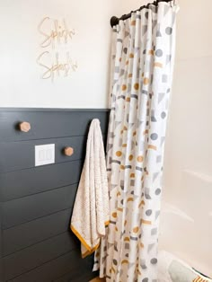 a bathroom with a shower curtain, towel rack and bath mat on the floor next to it