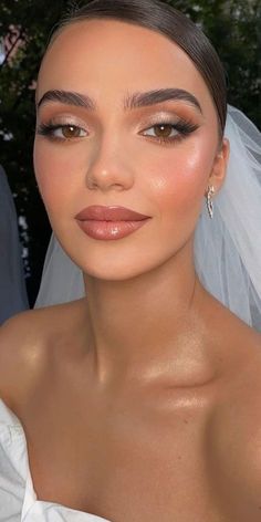 a woman wearing a veil and makeup looks at the camera while posing for a photo