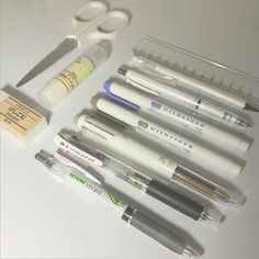 several pens, scissors and other medical supplies are arranged on a table