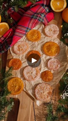 an overhead view of oranges and other food on a wooden table with greenery