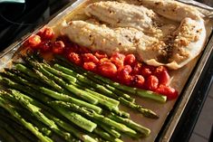 asparagus, chicken and tomatoes on a baking sheet