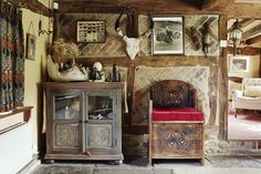 a living room filled with furniture next to a wall covered in pictures and deer heads