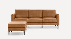 a brown leather couch and footstool sitting next to each other on a white background