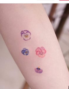 a woman's arm with four different flowers on the left side of her body