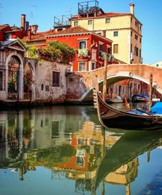 a gondola in the middle of a canal with buildings on both sides and water below