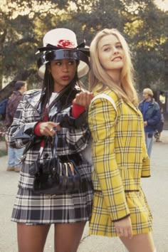 two women dressed in plaid outfits standing next to each other