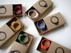 six different colored rings in a cardboard box