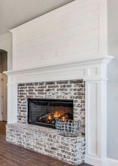 a living room with a fire place in the center and wood floors on both sides